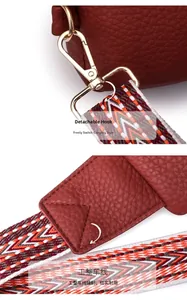 Detail view of detachable golden hook and wide geometric woven strap on burgundy chest bag