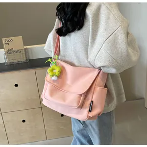 Roze canvas crossbodytas met gele bloemenhanger en handig zijvakje voor accessoires