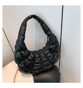 Close-up of black quilted cloud bag showing shiny PU leather and silver metal zipper