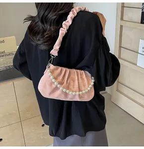 Detaillierte Nahaufnahme einer rosa gerafften Handtasche mit dekorativer Perlenkette und Riemen