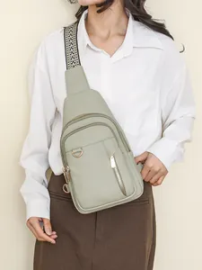 Fashionable sage green crossbody chest bag for women with woven strap and gold zippers