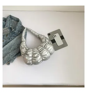 Detailed top view of silver pleated cloud bag with metallic texture and daily essentials