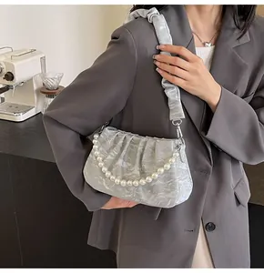 Detail of silver pleated cloud bag with pearl chain and ruffled shoulder strap