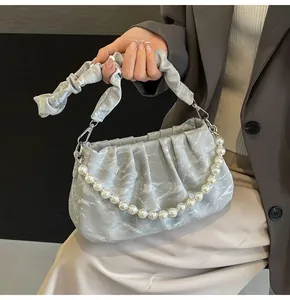 Detail of grey marble pattern cloud bag with pleated handle and white pearl chain strap