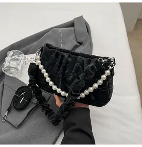 Detail einer schwarzen Ruched-Cloud-Bag aus Samt mit elegantem Kunstperlen-Griffstück