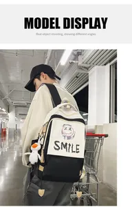 Detaillierte Seitenansicht des schwarz-weißen Rucksacks mit Graffiti-Lächeln und Plüsch-Entenanhänger