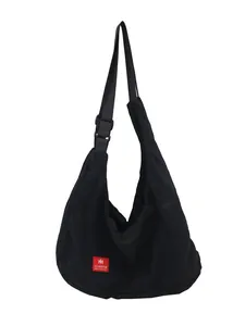 Black nylon crossbody bag with adjustable wide strap and red rectangular logo patch