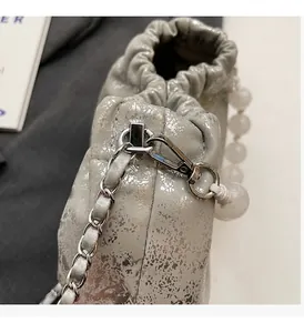 Nahaufnahme der silbernen Wolken-Tasche mit Perlengriff und Metallkettenriemen