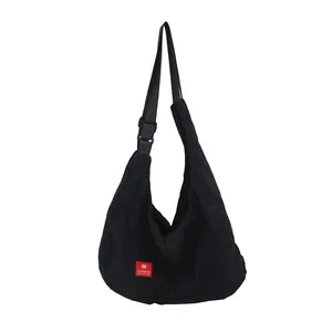 Large capacity black canvas hobo bag with adjustable strap and red square label