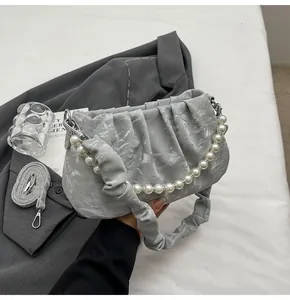 Detail der grauen Marmor-Cloud-Bag mit Perlenkette und geriffeltem Schultergurt