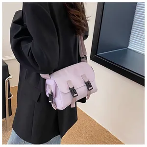 Detail of light purple nylon messenger bag showing black plastic buckles and strap