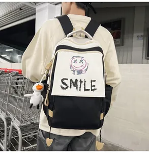Detailansicht eines schwarz-weißen Rucksacks mit SMILE-Aufdruck und Entenanhänger