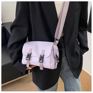 Detailed shot of lilac canvas messenger bag with buckle closure on a model