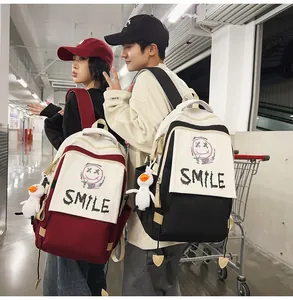 Detail eines Rucksacks im Farbblock-Design mit SMILE-Aufdruck und Enten-Plüschanhänger