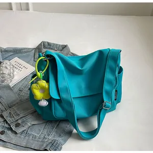 Blauwe canvas koerierstas detail met gele zonnebloem pluche hanger en verstelbare riem