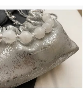 Detailansicht der silbernen Cloud Bag mit Perlengriff und Metallic-Struktur