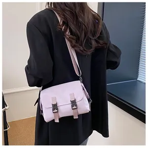 Back view of light purple messenger bag on model showing fit and compact crossbody design