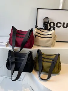 Minimalist nylon crossbody bag in four colors with multiple zipper pockets and adjustable strap