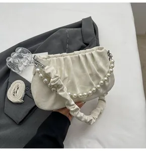 Detail der cremeweißen Cloud Bag mit Perlengriff und gerafftem PU-Leder in Marmoroptik