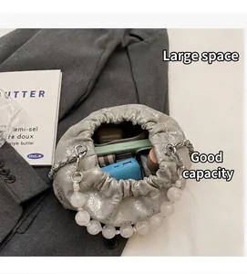 Silberne Falten-Beuteltasche mit Perlengriff und Ansicht des Innenraums