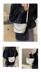 Detailed view of cream leather half-moon bag with chunky silver chain and long strap