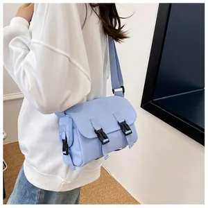 Close-up of light blue messenger bag featuring adjustable strap and buckle closure detail
