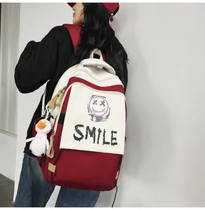Detail eines rot-weißen Rucksacks mit SMILE-Schriftzug und süßem Enten-Plüschtier