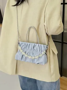 Light blue pleated cloud bag with silver chain strap and beaded detail on model