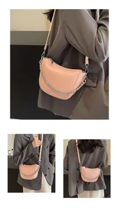 Macro view of light pink half-moon bag with silver chain detail and lychee leather texture