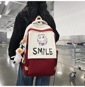 Detailsicht eines großen rot-weißen Segeltuchrucksacks mit Smile-Print und Entenanhänger