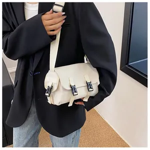 Detail of off-white crossbody messenger bag featuring adjustable straps and dual clip buckles