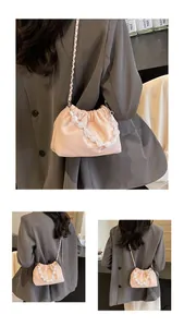 Detail der rosa gerafften Beuteltasche mit Perlengriff und eleganter Metallkette