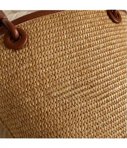 Macro detail of the hand-woven grass fiber texture and premium brown leather handle
