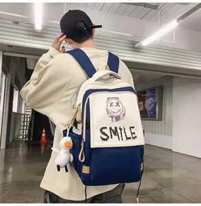 Detail eines blau-weißen Rucksacks mit Smile-Aufdruck und süßem Enten-Anhänger