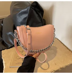 Close-up of pink crescent dumpling bag with pleated faux leather and silver chain