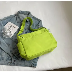 Detail van neon groene nylon crossbodytas met zijvak en een verstelbare schouderband