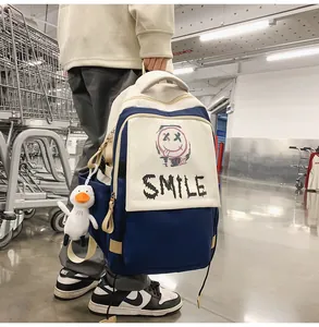 Seitenansicht des trendigen Colorblock-Rucksacks mit Smile-Print und Enten-Anhänger