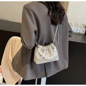 Detail der silbernen Beuteltasche mit großem Perlenriff und feiner Metallketten-Schultergurt
