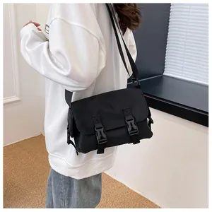 Detail of durable black nylon messenger bag with buckle closure and adjustable strap