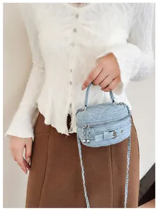 Close-up of quilted denim mini crossbody bag with chain strap and metal buckle details