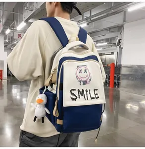 Außenaufnahme eines cremeweißen und blauen Rucksacks mit Graffiti und Entenanhänger