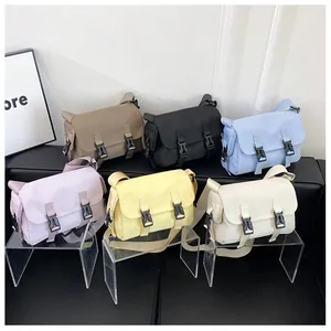 Close-up of multiple colors of small nylon messenger bags with double buckle closure
