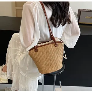 Detail of straw bucket bag with leather handles and white drawstring inner lining