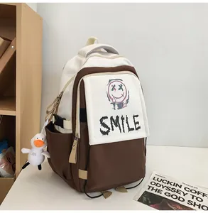 Nahaufnahme des weiß-braunen Nylon-Rucksacks mit Smile-Graffiti und Enten-Anhänger
