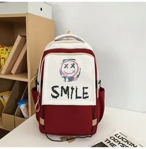 Detailansicht eines rot-weißen Rucksacks mit SMILE-Graffiti-Kunst auf Tisch