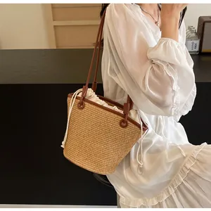 Detail of hand-woven straw bucket bag with leather strap and cotton drawstring liner