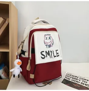 Detailansicht des rot-weißen Rucksacks mit SMILE-Aufdruck und süßem Enten-Anhänger-Zubehör