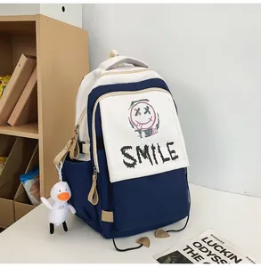 Detail eines blau-weißen Rucksacks mit Graffiti-Lächeln und Plüsch-Entenanhänger