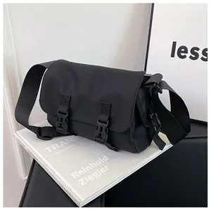 Detailed view of black nylon messenger bag with dual plastic buckles and adjustable strap
