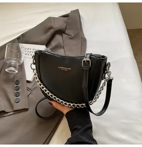 Close-up of black pleated crescent bag featuring gold logo and silver chain strap